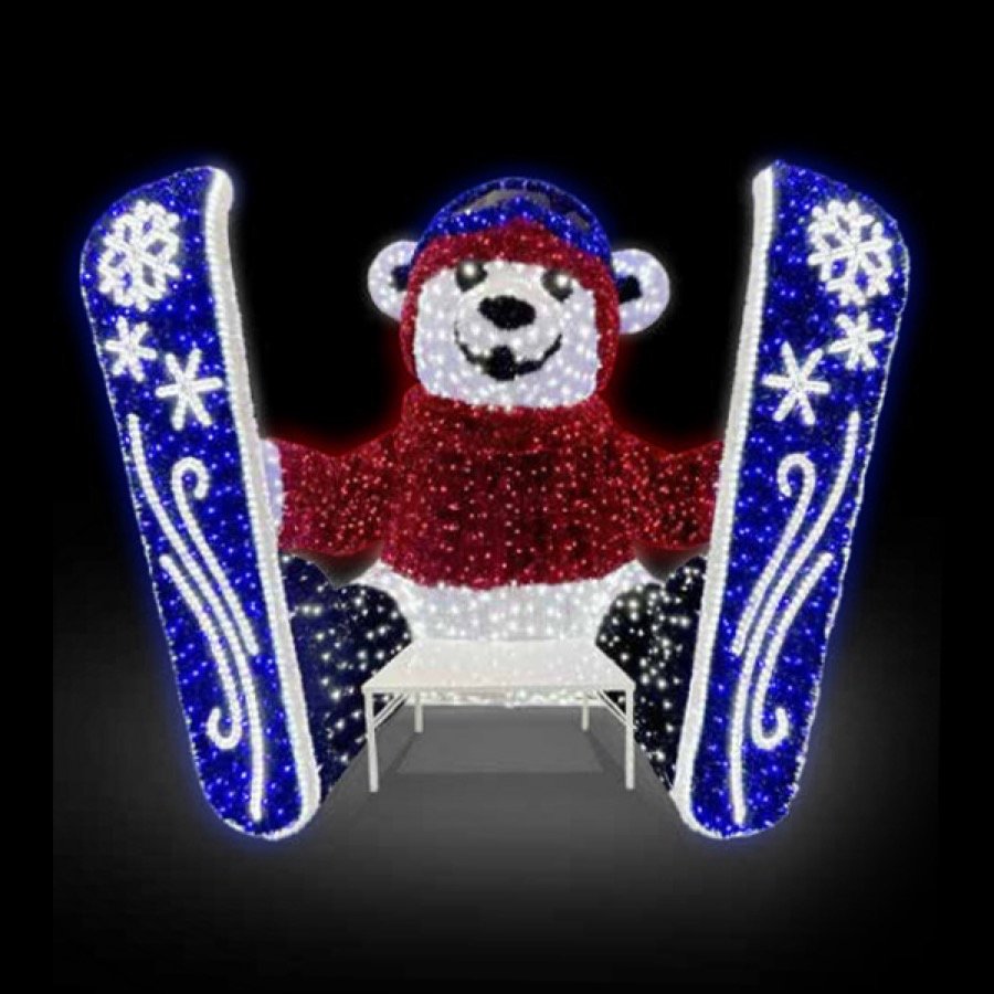 An illuminated polar bear display in blue and white lights framed by lit columns.