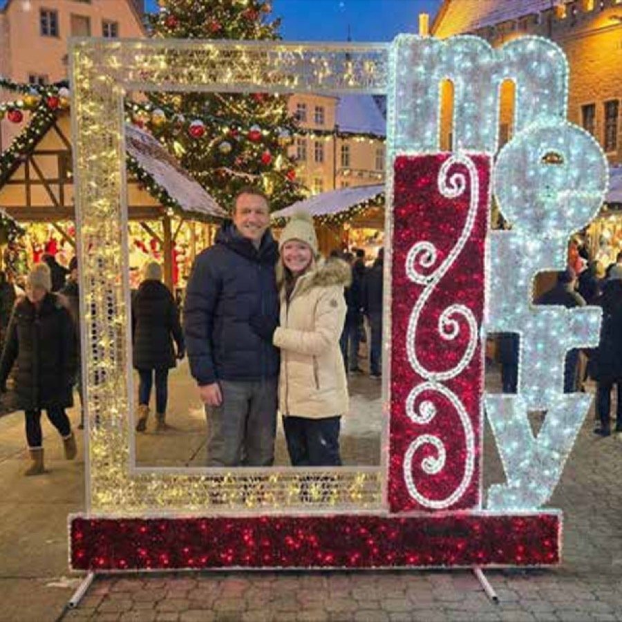 A lit MERRY picture frame photo opportunity on a pedestrian street.