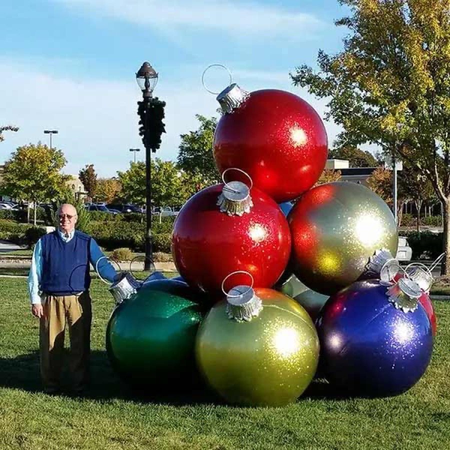 Stacks of oversized red and gold ornament balls beside a lamp post.