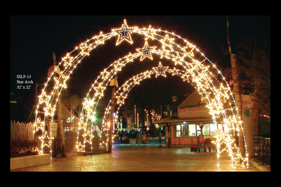 A lit star arch spanning a street at night.